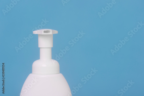 Hand sanitizer bottle or alcohol gel on blue background. Antiseptic, hygiene and health concept.