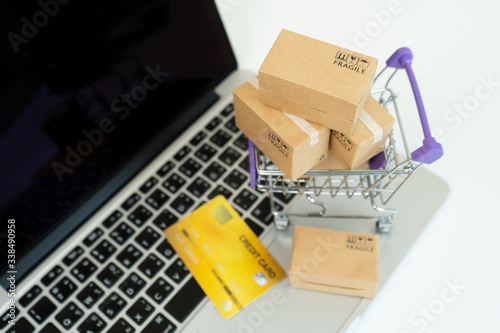 Online shopping or ecommmerce delivery service concept,Paper box on a laptop computer ,Easy shopping online concept photo