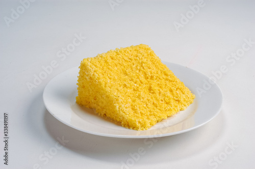 Gastronomy. Slice of the traditional corn couscous from northeastern Brazil, on a white plate