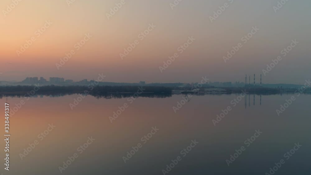 Peaceful sunset or sunrise aerial. City, water and industrial coast Peaceful sunset or sunrise aerial. City, water and industrial coast