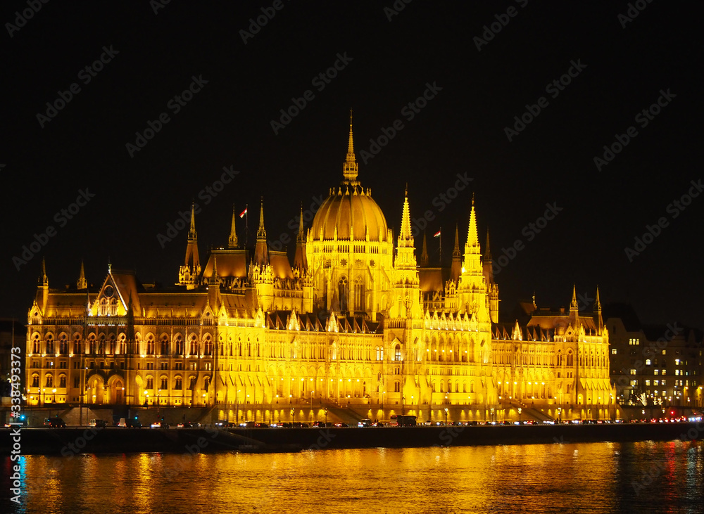 View of the Hungarian Parliament Building and the Danube river at night in Budapest, Hungary.