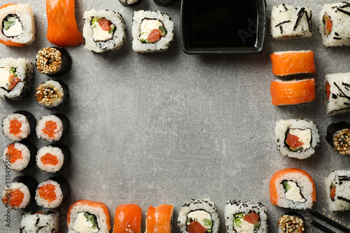 Flat lay with sushi rolls on gray background, space for text
