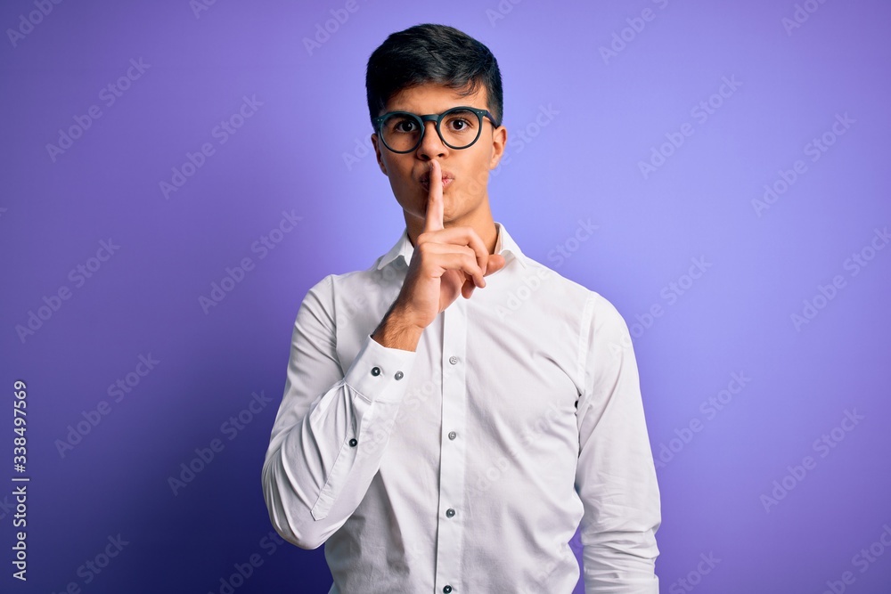 Young handsome business man wearing shirt and glasses over isolated purple background asking to be quiet with finger on lips. Silence and secret concept. Young handsome business man wearing shirt and glasses over isolated purple background asking to be quiet with finger on lips. Silence and secret concept.