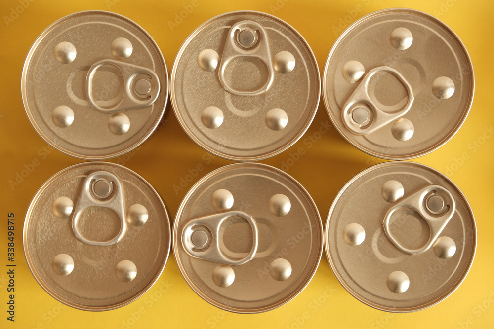 Canned food closed on yellow background. Top view. Copy, empty space for text Canned food closed on yellow background. Top view. Copy, empty space for text