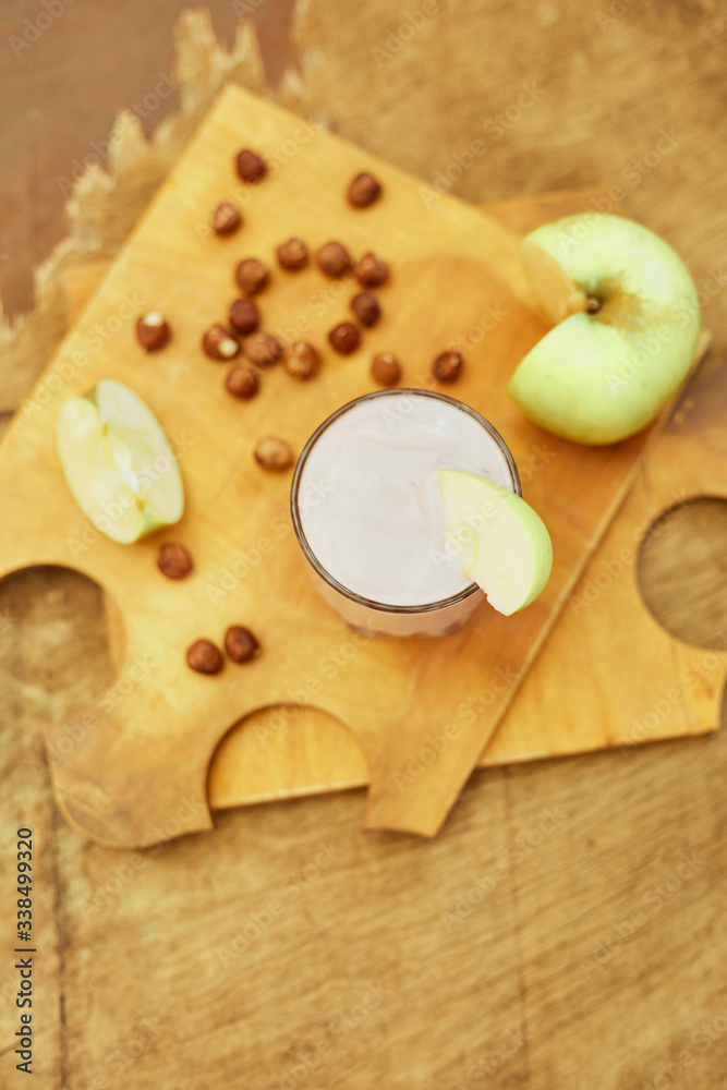 Yogurt with apple and nuts on a wooden background. Daylight. Yogurt with apple and nuts on a wooden background. Daylight.