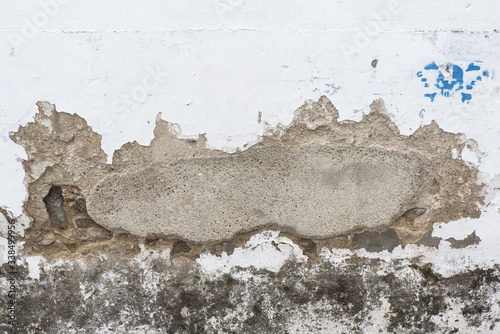 Obraz w ramie Old town house wall with fallen paint and a patch of cement with the brick underneath in sight natural light