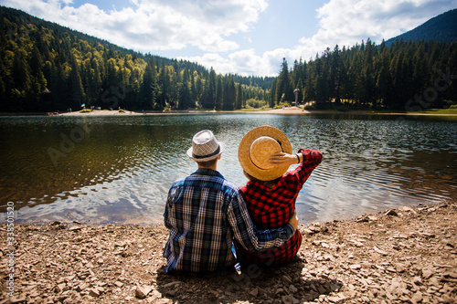Fototapet Travelers couple admire view of mountain lake