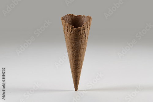 Empty, sweet, brown wafer cone for ice cream isolated on white. Concept of food, treats. Mockup, template for advertising and design. Close up