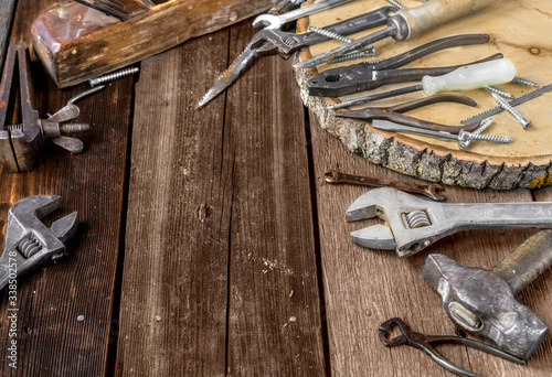 A set of metal tools in the workshop on an old rustic wooden background.concept.Father's day or labor day holiday.A greeting card or banner for your store or website.