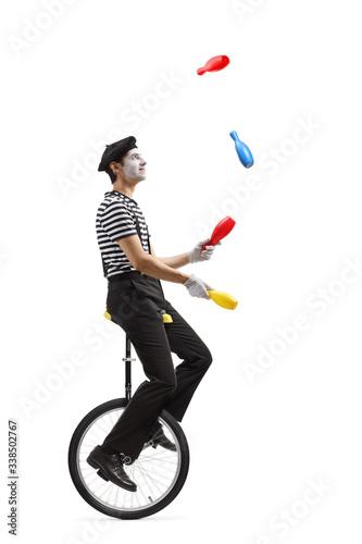 Pantomime guy riding a mono-cycle and juggling