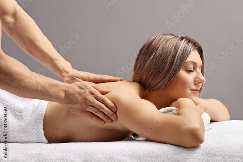 Woman enjoying a back massage by a male masseur