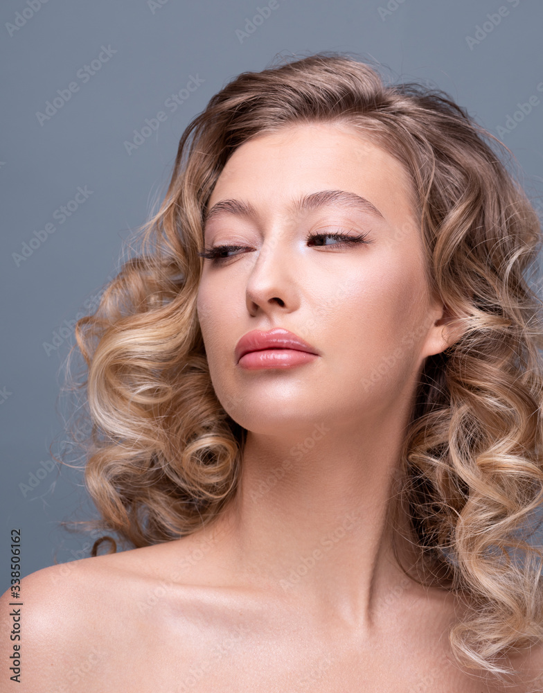 Fototapeta premium Beautiful girl with curly blond hair and flawless skin