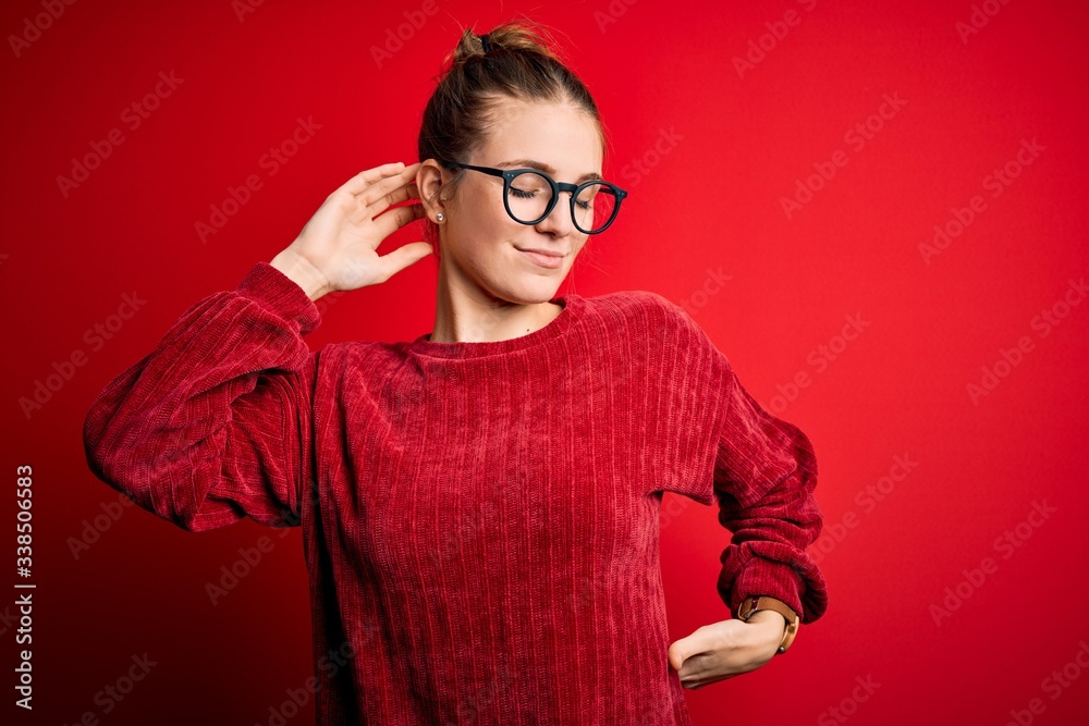 Young beautiful redhead woman wearing casual sweater over isolated red background stretching back, tired and relaxed, sleepy and yawning for early morning