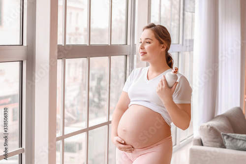 Sporty pregnant woman with bottle of water at home Free Download Sporty pregnant woman with bottle of water at home - GFXLoad