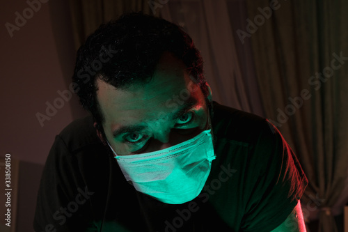 Portrait of a man in a medical mask. Isolation of the house in quarantine. The emotions of fear and impending doom. Global viral pandemic. The epidemic of coronavirus. Covid-19. 2019-nCoV. photo