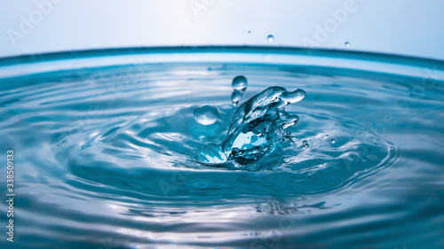 Water in the shape of two dolphins. Water splash close-up. Crown of blue water. Water drop. Frozen splashes.