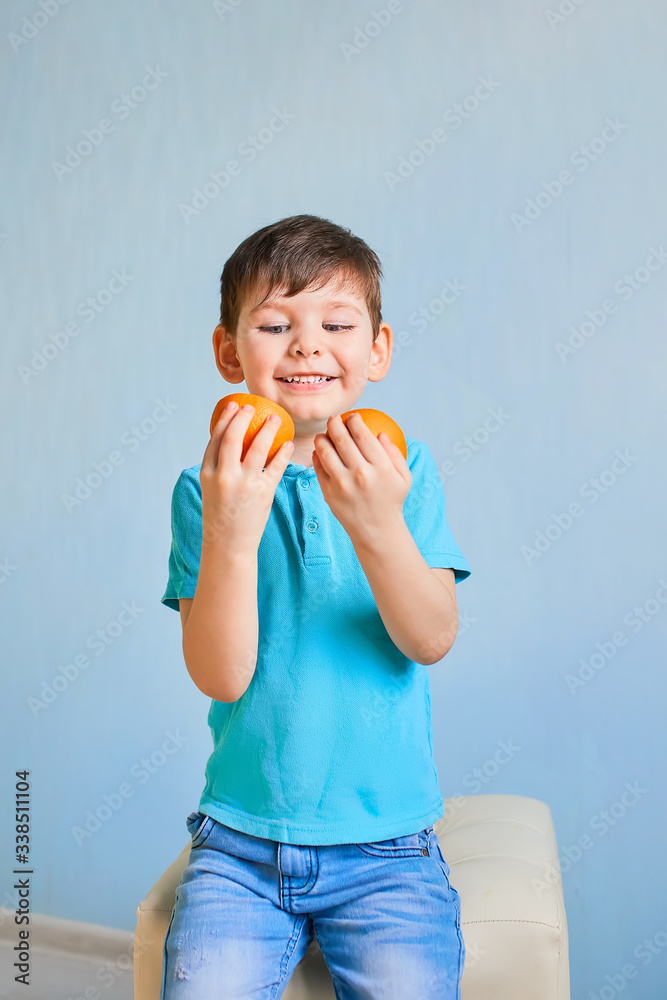 Young boy and girl with orange fruit on blue background Young boy and girl with orange fruit on blue background