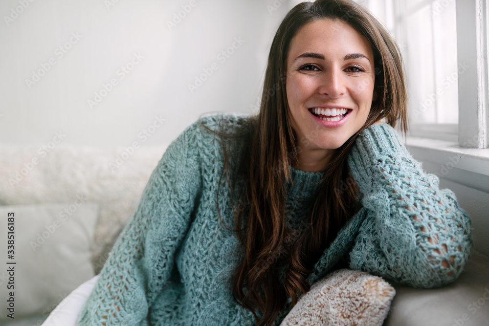 Casual pretty female sitting relaxed at home on sofa, perfect smile, straight white teeth portrait Casual pretty female sitting relaxed at home on sofa, perfect smile, straight white teeth portrait