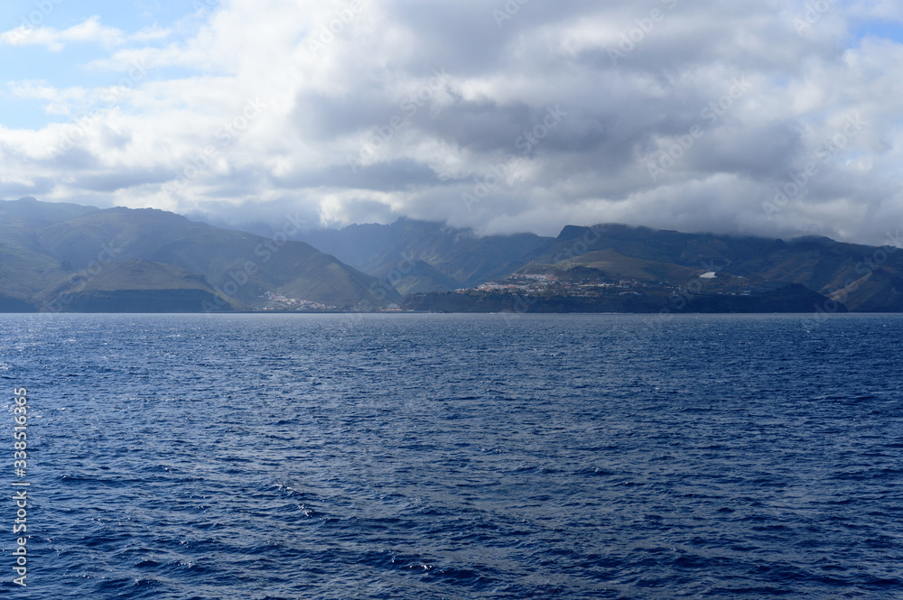 Magnificent views from the high seas with a beautiful enraged sky as a background the island of La Gomera. April 15, 2019. La Gomera, Spain Africa. Travel Tourism Photography Nature. Magnificent views from the high seas with a beautiful enraged sky as a background the island of La Gomera. April 15, 2019. La Gomera, Spain Africa. Travel Tourism Photography Nature.