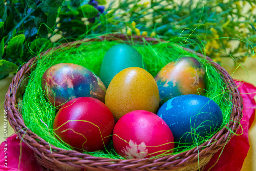 Green grass nest in a basket with colored chicken Easter eggs, multicolored painted eggs, Easter tradition, plastic flower as a decoration on the back, celebration concept
Green grass nest in a basket with colored chicken Easter eggs, multicolored painted eggs, Easter tradition, plastic flower as a decoration on the back, celebration concept