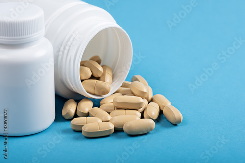 antiviral medical tablets in white medical bottles on blue background