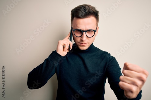Young handsome caucasian man having a conversation talking on smartphone annoyed and frustrated shouting with anger  crazy and yelling with raised hand  anger concept