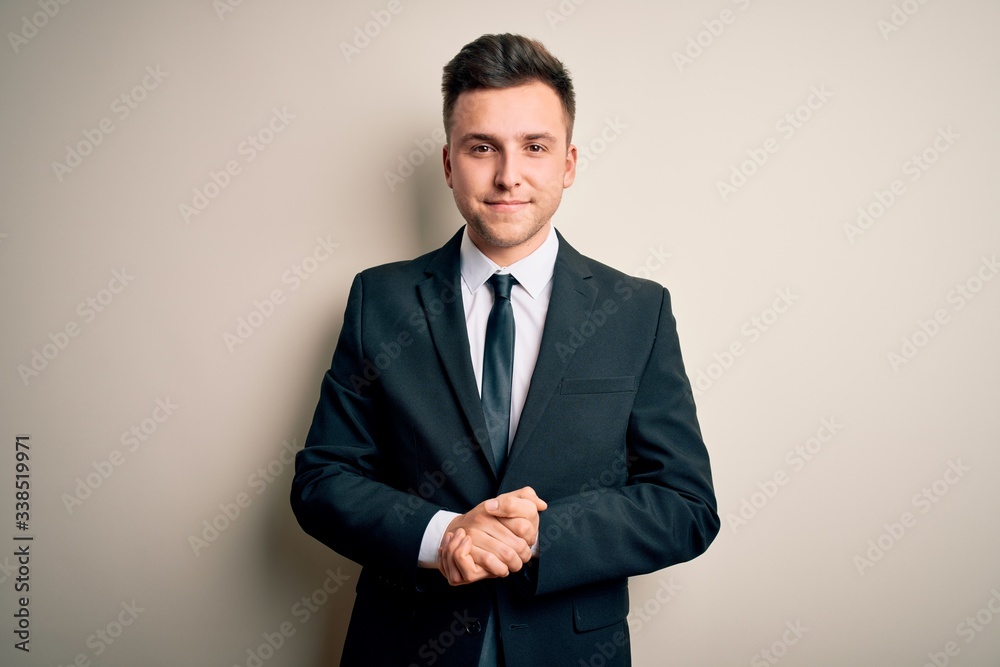 Young handsome business man wearing elegant suit and tie over isolated background with hands together and crossed fingers smiling relaxed and cheerful. Success and optimistic Young handsome business man wearing elegant suit and tie over isolated background with hands together and crossed fingers smiling relaxed and cheerful. Success and optimistic