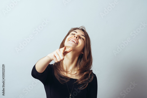 Photos funny cute brunette girl points finger and taunts