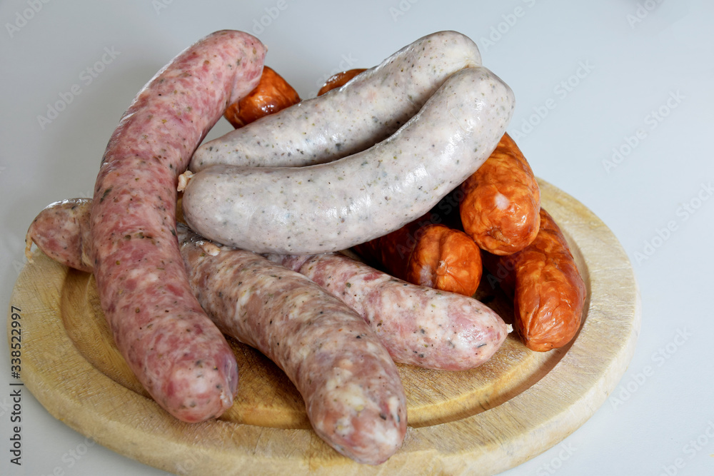 various types of sausages for cooking and baking on a wooden board