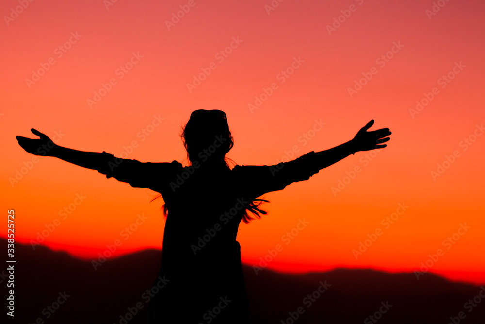 His arms lifted up in the sunset, high energy woman