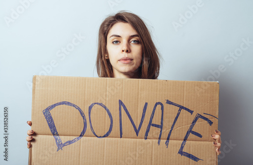 young woman showing board with text: Donate © aeroking