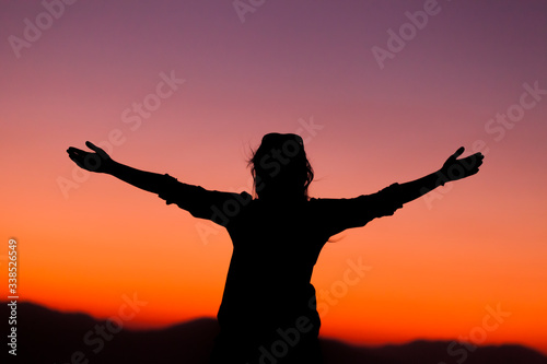 His arms lifted up in the sunset, high energy woman
