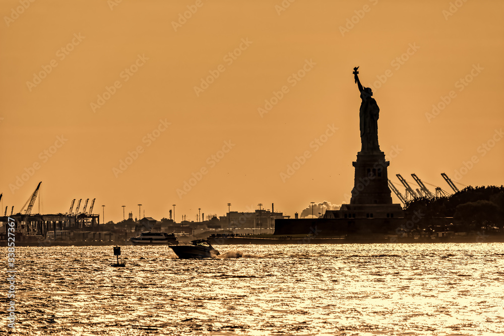 Water traffic on the Hudson River around Statue of Liberty at sunset, New York