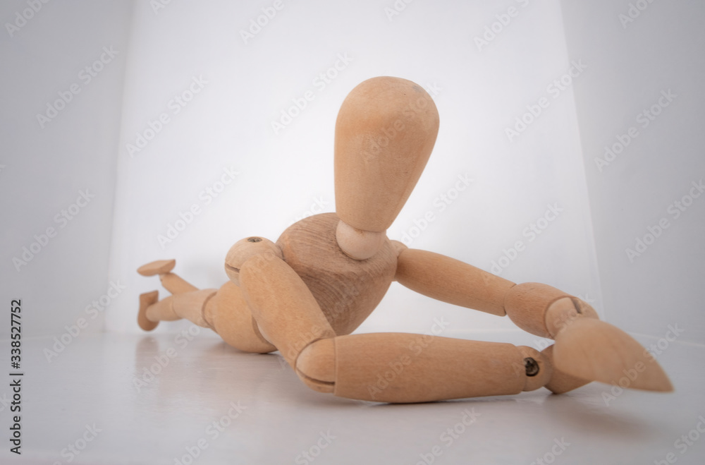 Boneco manequim de madeira articulado deitado com fundo branco Boneco manequim de madeira articulado deitado com fundo branco