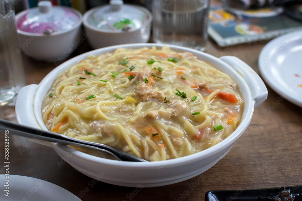 Chicken gravy noodles or chowmein served in a white bowl over moody background. Selective focus