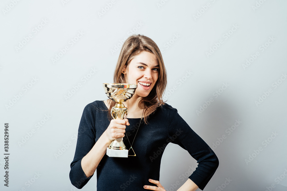young girl holding a prize cup and happy young girl holding a prize cup and happy