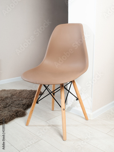 Brown color chair, modern designer chair in the interior. Plastic chair. Series of furniture