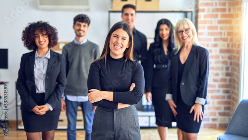 Group of business workers smiling happy and confident. Posing together with smile on face looking at the camera, young beautiful woman with crossed arms at the office