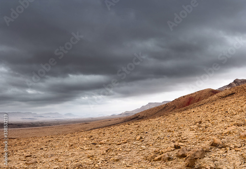 Dark stormy clouds over a rocky canyon, panorama from several shots.