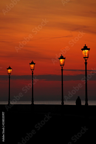 four lanterns on the city promenade in the evening sunset twilight
