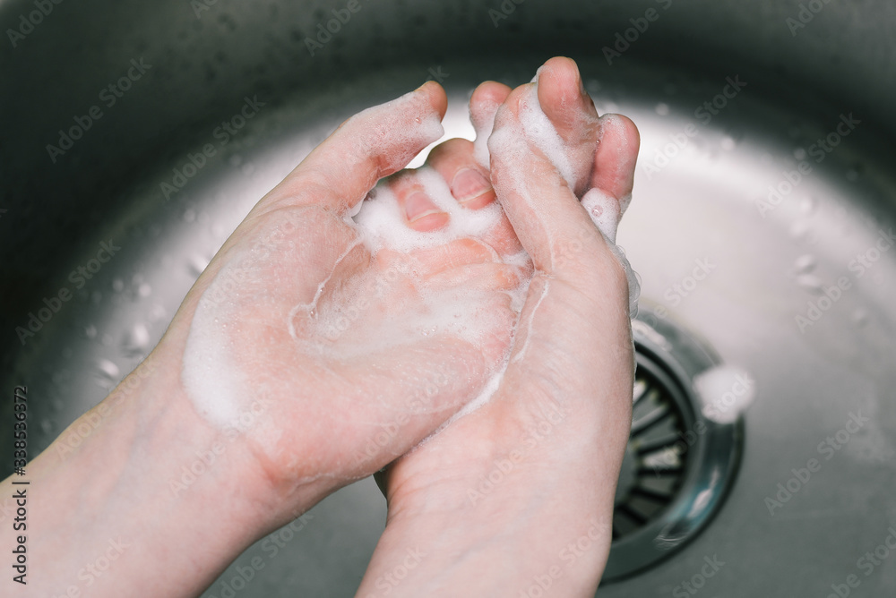 Hand washing with soap in the sink. Antibacterial soap disinfectant. Prevent the spread of bacteria and avoid coronavirus infection.