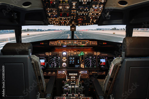 Full view of cockpit modern Boeing aircraft before take-off. Airplane is ready to fly. Daytime shot in cabin. Safety flight