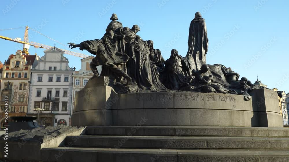Jan Hus statue at Old Town square historical center of Prague in Czechia. Movement reveals Old Town Square and Astronomical clock tower. Jan Hus statue at Old Town square historical center of Prague in Czechia. Movement reveals Old Town Square and Astronomical clock tower.