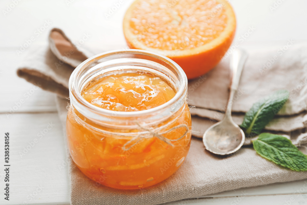 Jar of orange jam on white table Jar of orange jam on white table