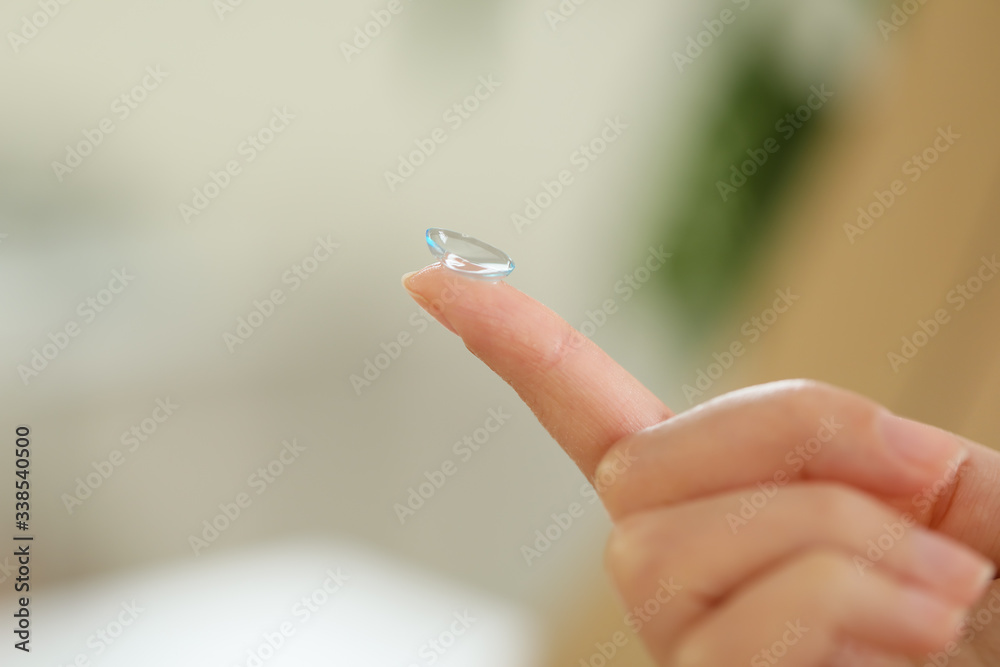Young African-American woman with contact lens at home, closeup Young African-American woman with contact lens at home, closeup