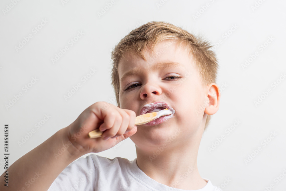 cute boy posing with bamboo toothbrush in his mouth, child brushes his teeth cute boy posing with bamboo toothbrush in his mouth, child brushes his teeth