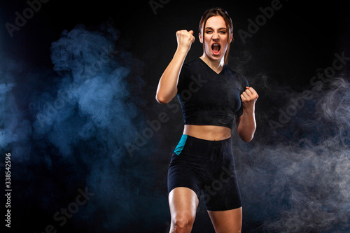 Sprinter and runner girl. Running concept. Woman running on the black background. The concept of a healthy lifestyle and sport. Woman in sportswear.