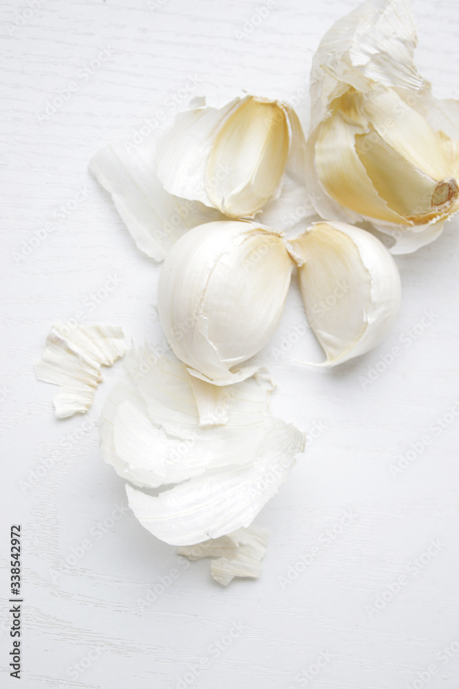 garlic cloves on white table garlic cloves on white table