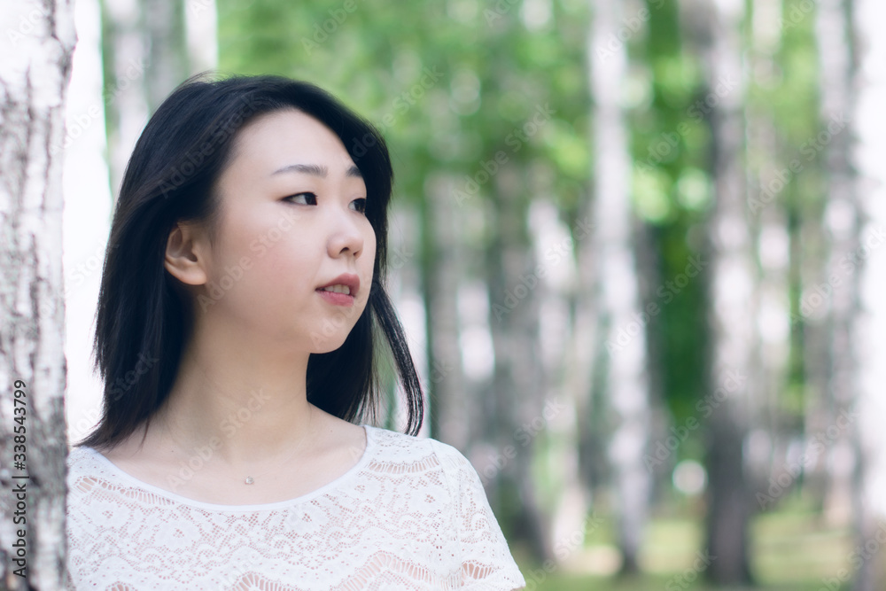 Portrait of a beautiful Asian young girl in nature. Copy space.