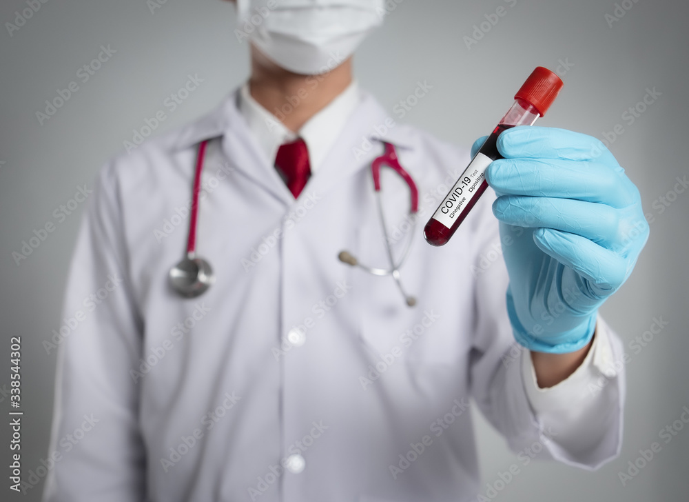 Hand of a doctor holding test tube with blood for Covid-19 (coronavirus) analyzing. Laboratory testing patient’s blood Hand of a doctor holding test tube with blood for Covid-19 (coronavirus) analyzing. Laboratory testing patient’s blood